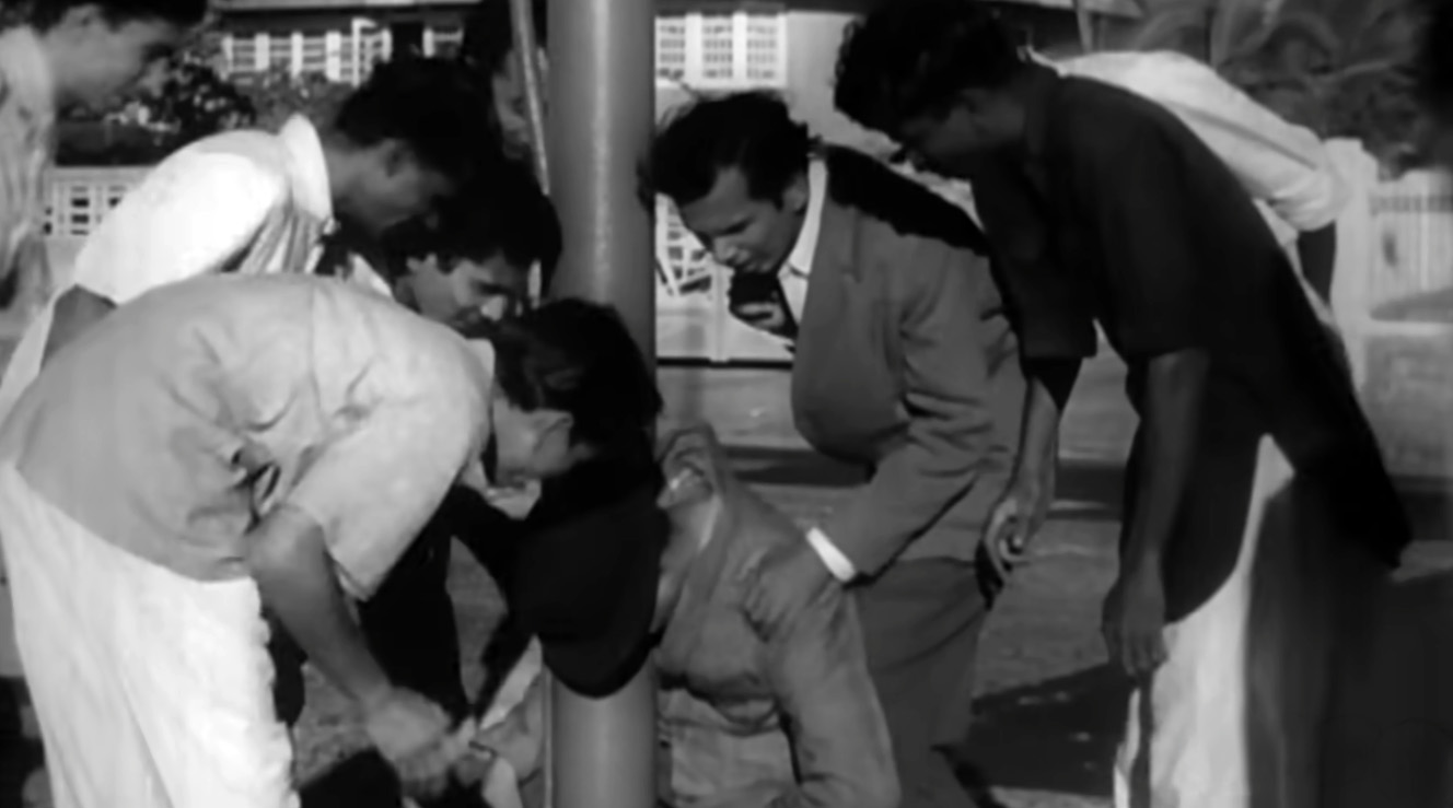 Guru Dutt slumping down a lamppost
