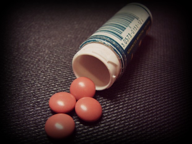 The emptied bottle of sleeping pills lay open by the cushions.